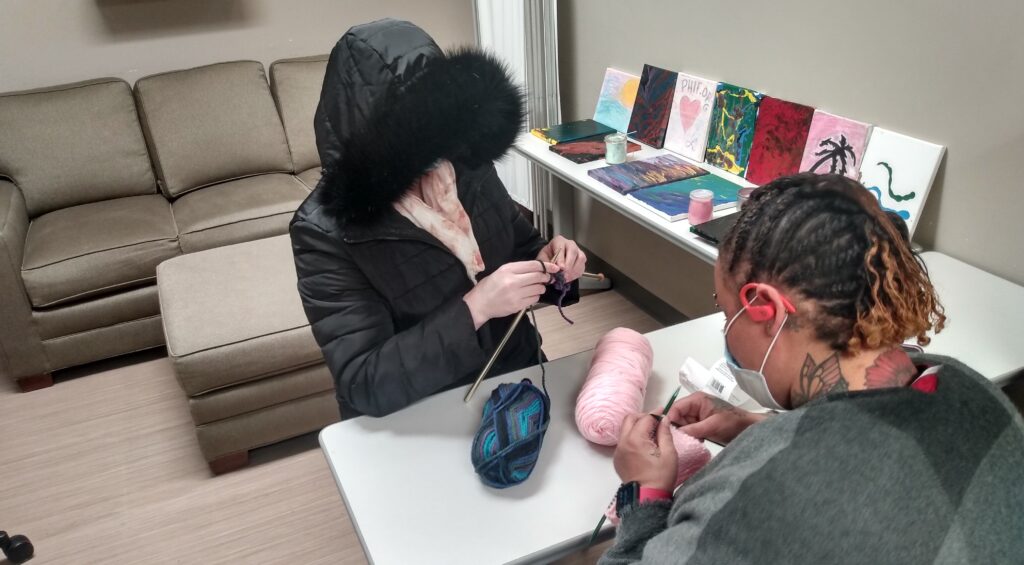 Knitting class guests learn to knit at an activity in our community room